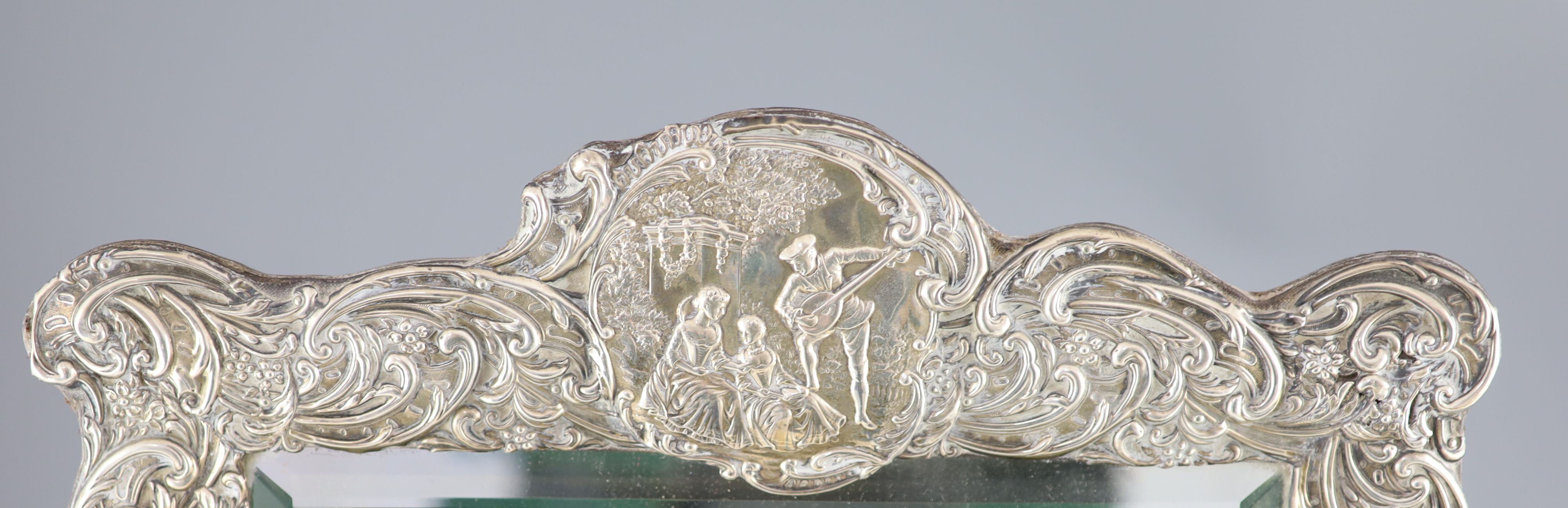 An Edwardian repousse silver mounted toilet mirror, Henry Matthews, Birmingham, circa, 1905,